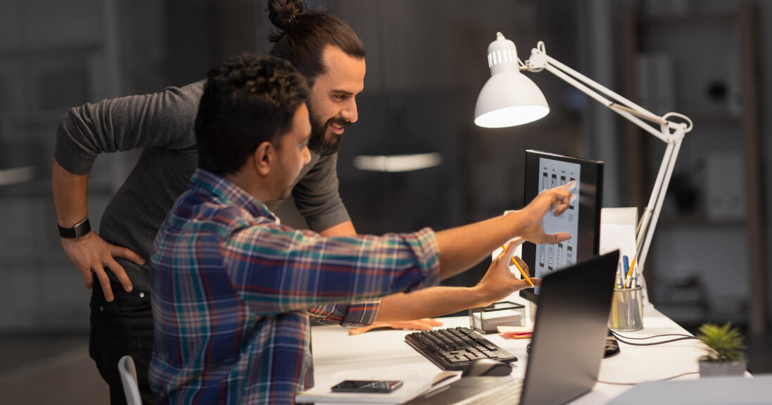 Two men collaborating on a custom web design in a professional office setting